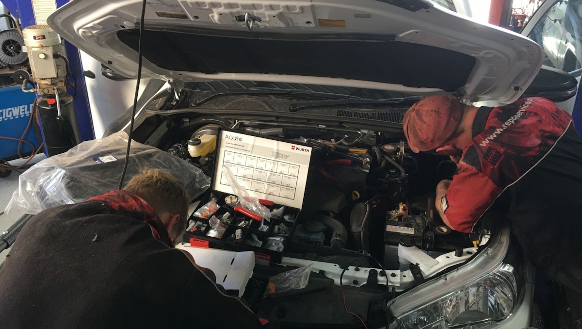 Auto technicians working on a vehicles eletrical system